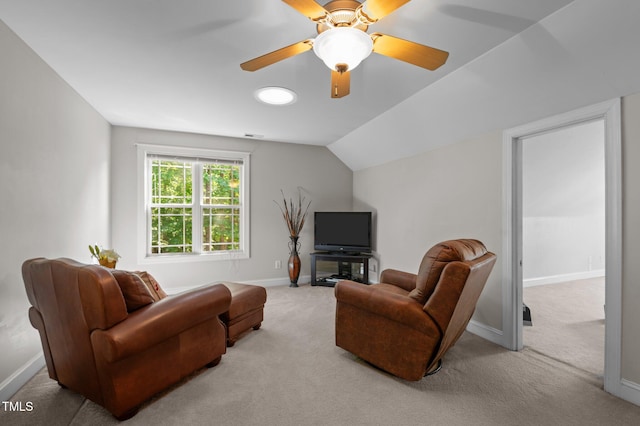living area featuring baseboards, ceiling fan, light carpet, and lofted ceiling