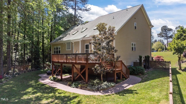 back of property featuring roof with shingles, a lawn, a deck, fence, and stairs
