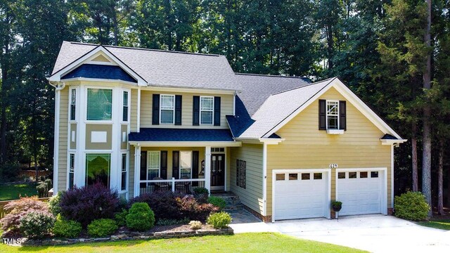 624 Moultonboro Ave, Wake Forest, NC 27587 - traditional home with a porch, an attached garage, driveway, and roof with shingles