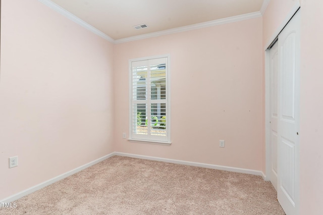 unfurnished bedroom featuring baseboards, crown molding, visible vents, and carpet