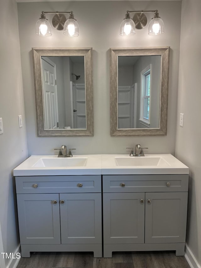 1165 John Mitchell Rd, Youngsville, NC 27596 - bathroom featuring double vanity, a sink, baseboards, and wood finished floors