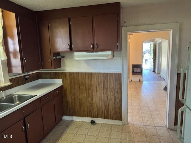 207 Harris St, Norlina, NC 27563 - kitchen featuring a sink, fridge, light floors, arched walkways, and light countertops