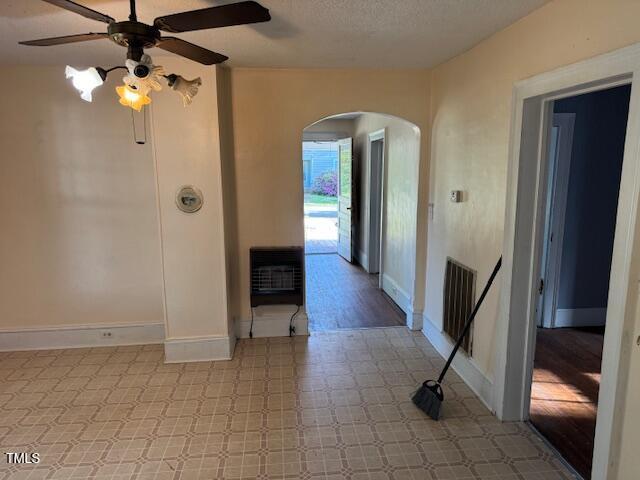207 Harris St, Norlina, NC 27563 - interior space featuring a ceiling fan, heating unit, tile patterned floors, arched walkways, and baseboards