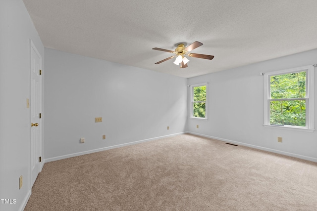 spare room with ceiling fan, carpet flooring, a textured ceiling, and baseboards