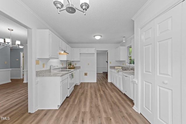 kitchen featuring white appliances, a chandelier, a sink, light wood-style flooring, and crown molding