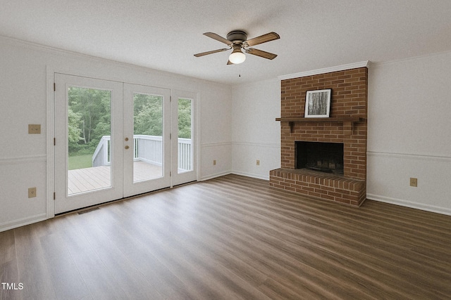 unfurnished living room with wood finished floors, french doors, ornamental molding, a ceiling fan, and a fireplace