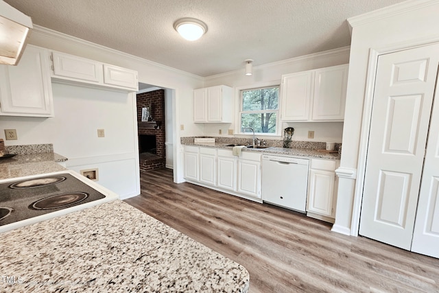 kitchen featuring white appliances, a sink, a textured ceiling, ornamental molding, and light wood-style floors