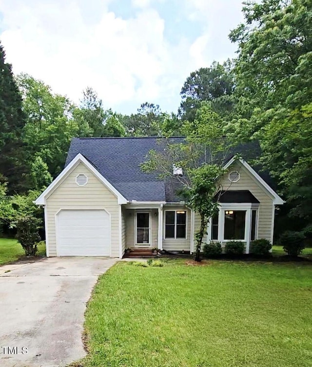 view of front of property featuring an attached garage, concrete driveway, a front yard, and roof with shingles