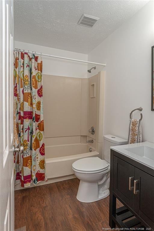 204 Bayfield Loop, Fayetteville, NC 28314 - bathroom featuring wood finished floors, vanity, shower / bath combination with curtain, toilet, and a textured ceiling