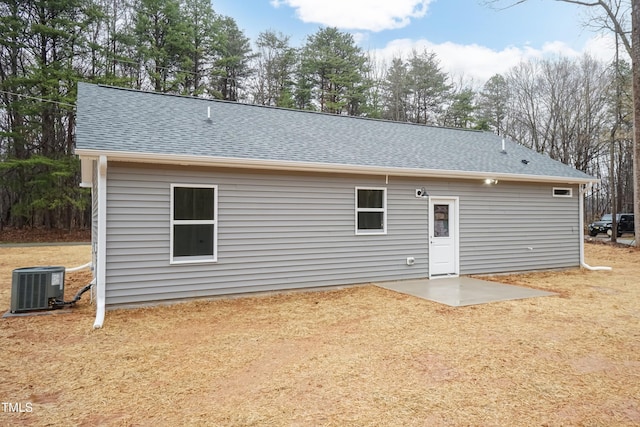 rear view of house featuring a patio area, cooling unit, and a shingled roof