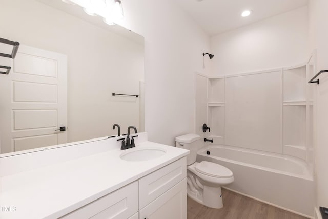 full bathroom with shower / washtub combination, wood finished floors, vanity, and toilet