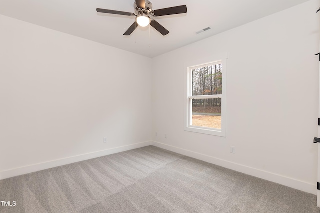 empty room with visible vents, a ceiling fan, baseboards, and light carpet