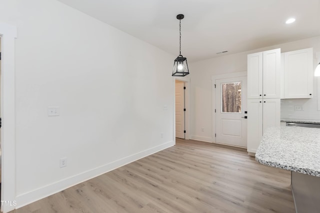 unfurnished dining area with baseboards, light wood-style floors, visible vents, and recessed lighting