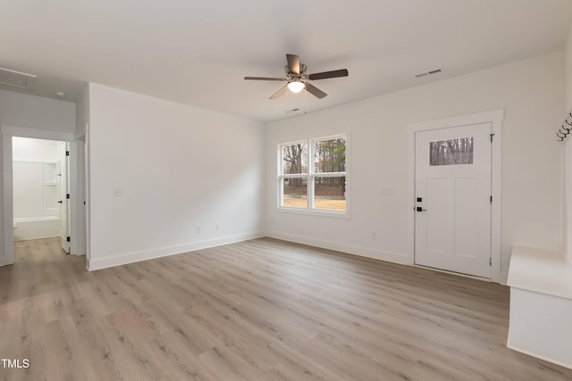 interior space with light wood-type flooring, visible vents, a ceiling fan, and baseboards