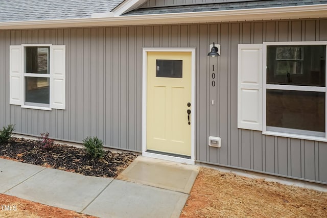 doorway to property with a shingled roof