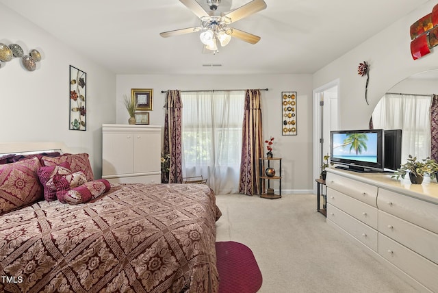 bedroom featuring light carpet, baseboards, visible vents, and ceiling fan