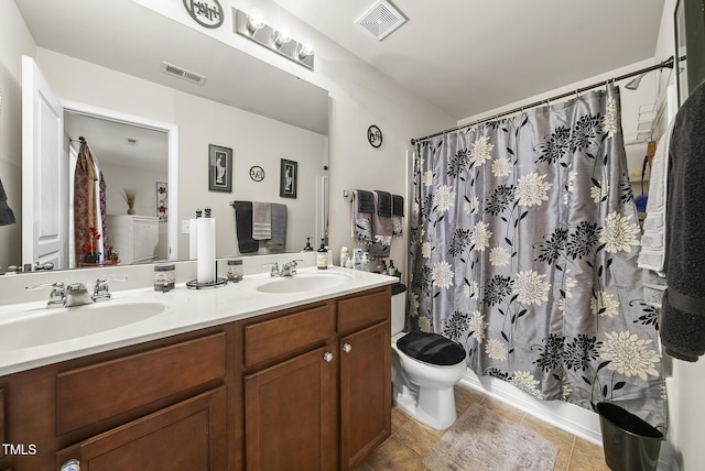 bathroom featuring visible vents, toilet, and a sink