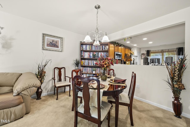 dining space with a chandelier, baseboards, light colored carpet, and recessed lighting