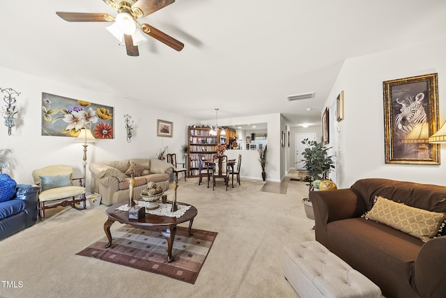 living area with light colored carpet, visible vents, and ceiling fan with notable chandelier