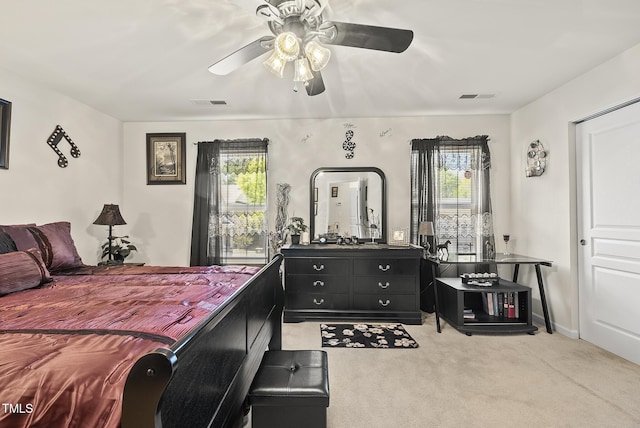 bedroom featuring visible vents, light colored carpet, and ceiling fan