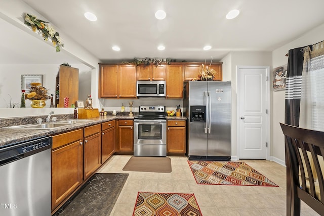 kitchen featuring a sink, recessed lighting, appliances with stainless steel finishes, brown cabinetry, and light tile patterned floors