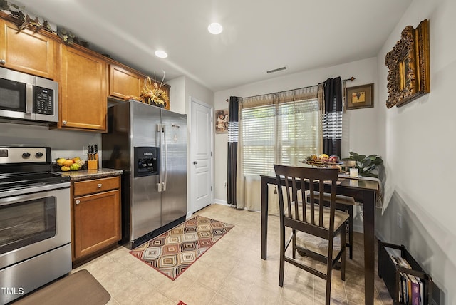 kitchen with recessed lighting, brown cabinetry, visible vents, and stainless steel appliances