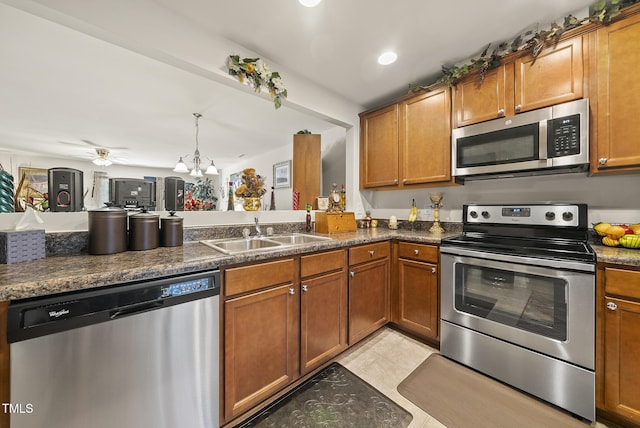 kitchen featuring stainless steel appliances, a sink, and brown cabinetry