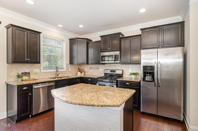 kitchen featuring a sink, dark brown cabinetry, light stone countertops, and stainless steel appliances