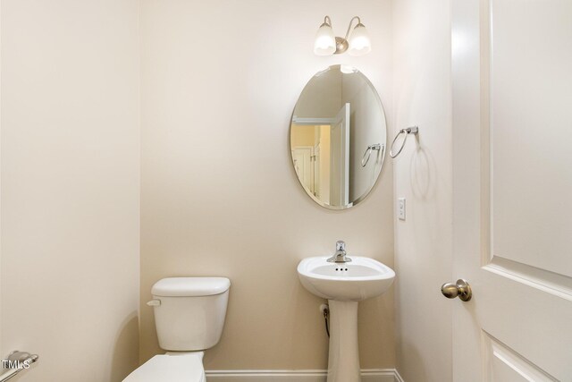 bathroom featuring baseboards and toilet