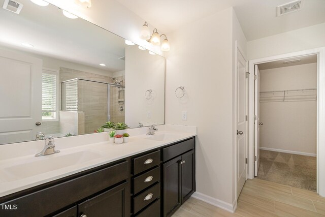 full bath featuring visible vents, a shower stall, and a sink