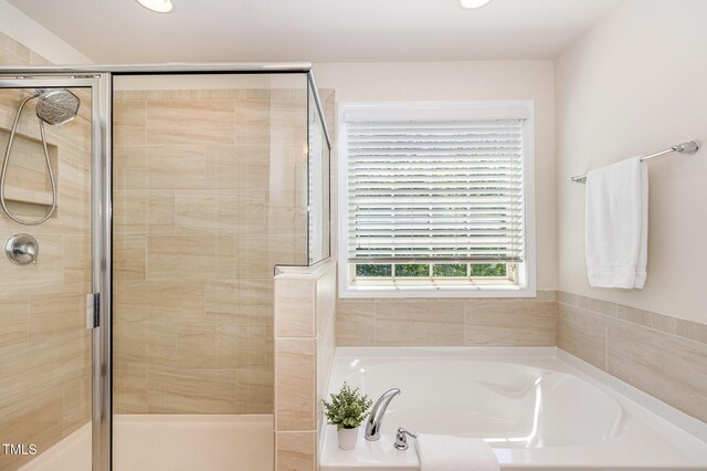 bathroom with recessed lighting, a garden tub, and a stall shower