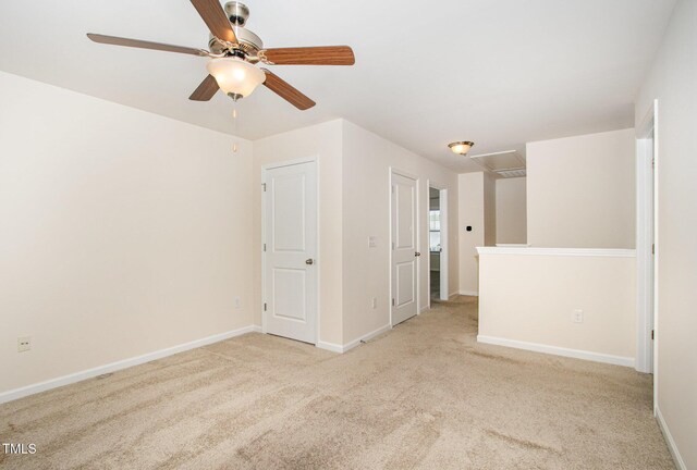 spare room with a ceiling fan, baseboards, and carpet