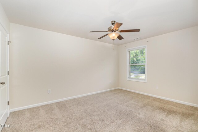 empty room featuring baseboards, visible vents, a ceiling fan, and light colored carpet
