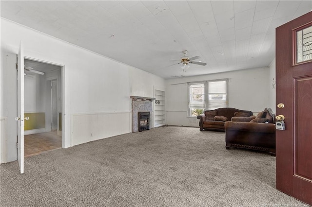 107 Church St, Red Springs, NC 28377 - carpeted living area with a ceiling fan, a fireplace, and a wainscoted wall