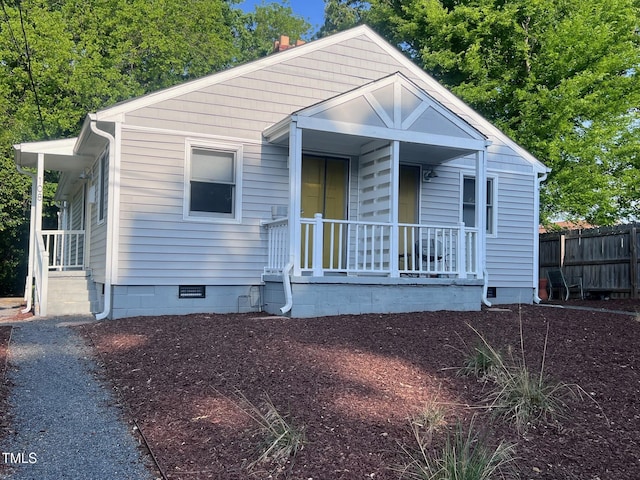 view of front of property featuring crawl space, covered porch, and fence