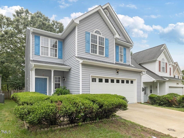traditional home with a garage, central AC unit, and concrete driveway