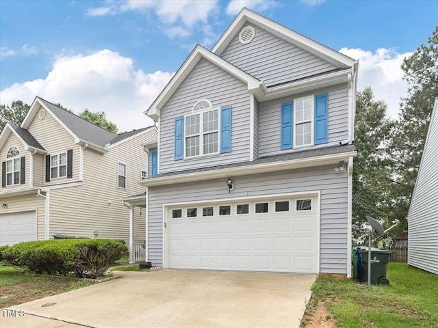 traditional-style home featuring a garage and driveway