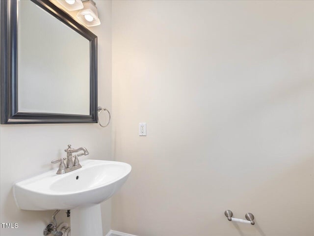 bathroom with a sink and baseboards