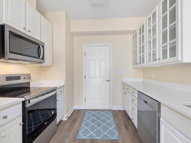 kitchen featuring appliances with stainless steel finishes, dark wood-type flooring, and light countertops