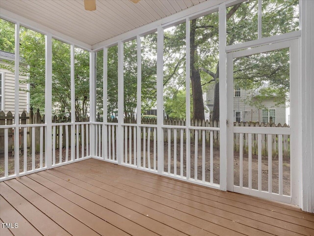 unfurnished sunroom featuring a ceiling fan