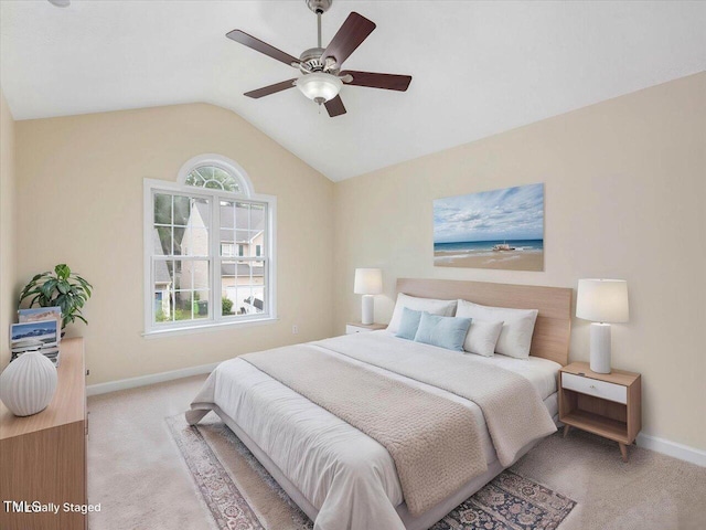 bedroom featuring light colored carpet, baseboards, lofted ceiling, and ceiling fan