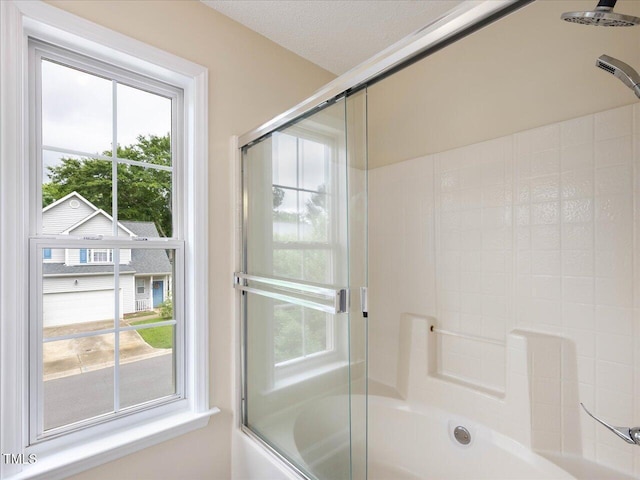 bathroom featuring bath / shower combo with glass door