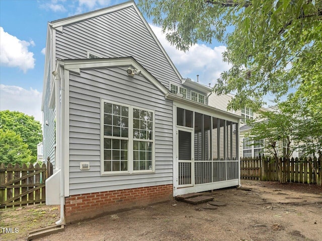 rear view of house with fence and a sunroom