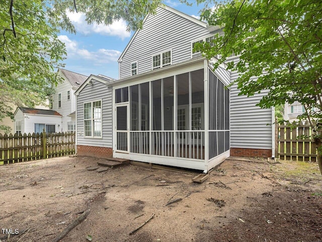 rear view of house with fence and a sunroom