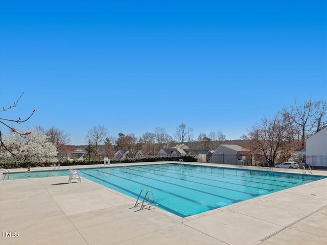 community pool featuring fence and a patio area