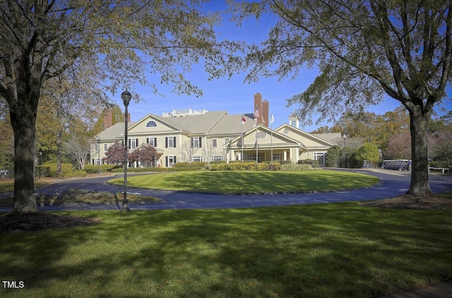 view of front facade featuring curved driveway and a front lawn