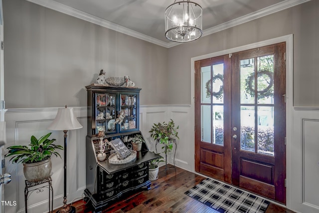 entryway featuring french doors, a decorative wall, a notable chandelier, and wood finished floors