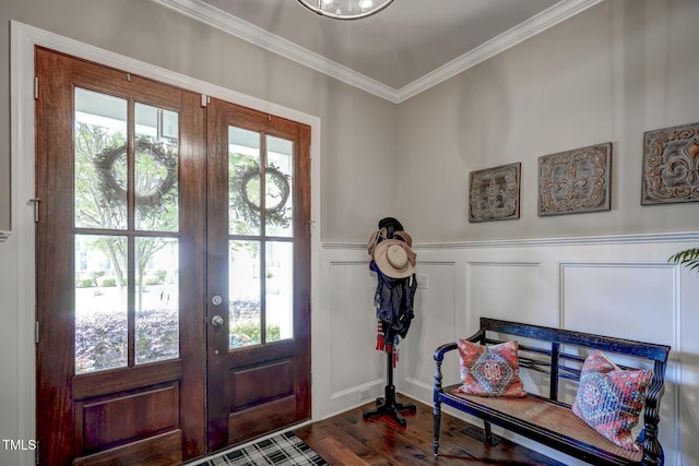 entryway featuring crown molding, wainscoting, a decorative wall, dark wood finished floors, and french doors
