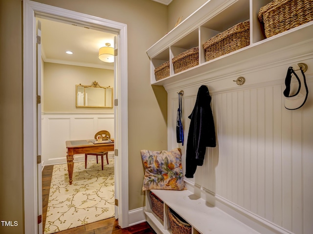 mudroom featuring a wainscoted wall, ornamental molding, a decorative wall, and dark wood-style floors