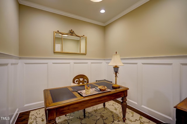 home office featuring crown molding, a wainscoted wall, a decorative wall, and dark wood-type flooring
